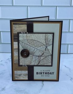 a birthday card with a button on it and some leaves in the background that says, a happy birthday to you