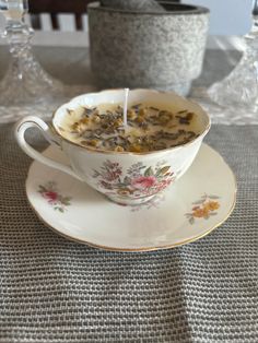 a teacup filled with flowers sitting on top of a saucer