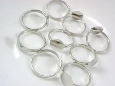 a bunch of silver rings sitting on top of a white table