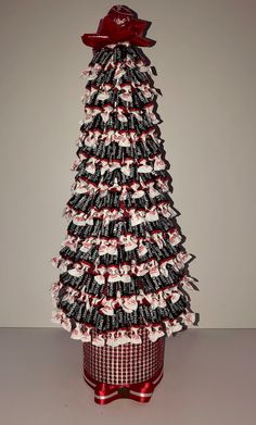 a christmas tree made out of wine bottles with bows on the top and ribbon at the bottom