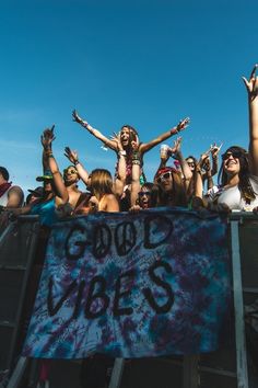 a group of people standing in front of a crowd holding onto a sign that says loud vibes