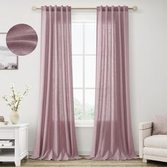 a living room with a couch, chair and window covered in pink drapes that are hanging on the wall