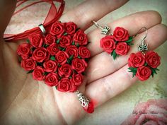 red roses are being held in the palm of someone's hand with matching earrings