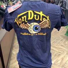 Von Dutch | Shirts | Von Dutch Eyeball So Cal Tshirt | Poshmark Blue Graphic Tee With Back Print, Casual Blue T-shirt With Back Print, Blue Short Sleeve Top With Back Print, Casual Blue Tops With Back Print, Blue Relaxed Fit Top With Back Print, Converse Shirt, Versace Shirts, Dutch Blue, Baggy Tee