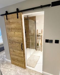 an open door leading to a bathroom with a walk in shower