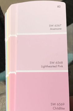 a person holding up a pink and white color swatch in front of their face