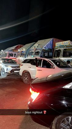 several cars parked in a parking lot at night