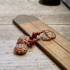 These colors just drew me in! They are so rich and beautiful together. I now have a whole selection of beads that will mix and match with this series. When I look at these, I initially think fall or autumn, then I gravitate to considering Christmas. These items are all available with antique brass or copper. Every earring is available with titanium ear wire, if you need them for your sensitive ears. Even if you don't need them, they look and feel great. These long dangle earrings are perfect for Red Drop Clip-on Earrings As Gift, Red Drop Clip-on Earrings For Gift, Red Dangle Clip-on Earring, Red Single Earring As Gift, Red Pierced Drop Earrings, Red Dangle Single Clip-on Earring, Single Red Earring For Gift, Single Red Earring Gift, Vintage Red Beaded Earrings As Gift