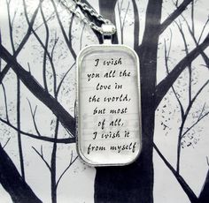 a necklace with a poem on it hanging from a tree