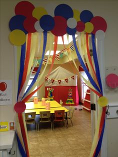 an open door with balloons and streamers hanging from it's sides in a room