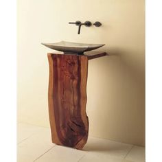 a bathroom sink made out of wood and metal faucet mounted to the wall