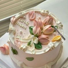 there is a cake with flowers on the top of it and icing around the edges