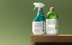 two bottles of living green are sitting on a wooden shelf with a spray bottle next to it