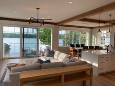 a living room filled with furniture next to a kitchen and an open concept dining area