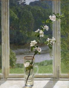 a vase filled with white flowers sitting on top of a table next to a window