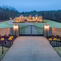 an aerial view of a home at night with lights on the front gate and driveway