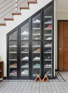 a pair of shoes sitting on top of a tiled floor next to a wooden door