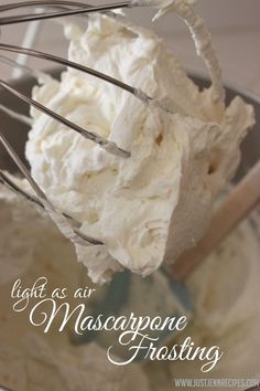 a whisk is being used to make mascarpone frosting in a glass bowl