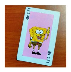 a playing card with an image of spongebob on the front, and five clovers on the back