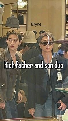 two men standing next to each other in front of a store window with the words rich father and son duo