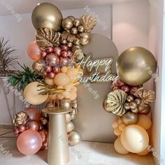 a birthday party with balloons and decorations in gold, pink and silver colors on the wall