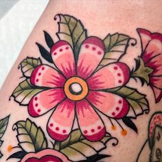 a close up of a tattoo with flowers on it