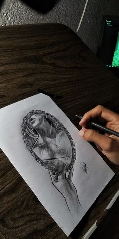 a person is drawing on paper with a pen