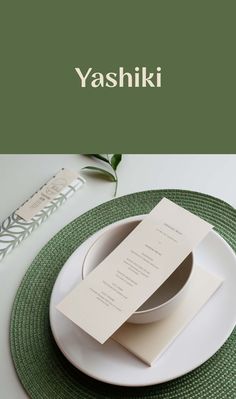 a white plate topped with a fork and knife next to a green place mat on top of a table