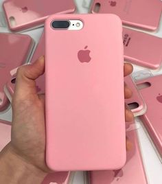 a person holding an iphone case in front of pink cases on top of each other