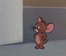 a cartoon mouse standing in front of a wall