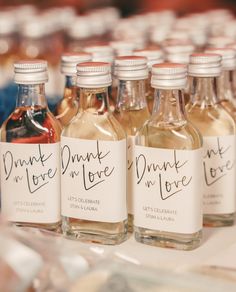 six bottles of wine are lined up on a table with labels that say, drunk in love