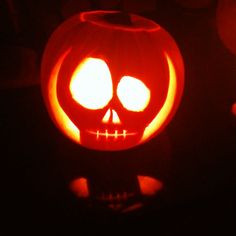 a jack o lantern is lit up in the dark with its eyes glowing orange and white