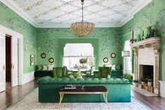 a living room filled with green furniture and walls painted in shades of blue, green and white