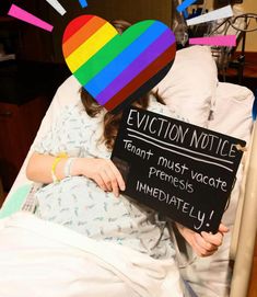 a woman in a hospital bed holding a sign that says eviction notice