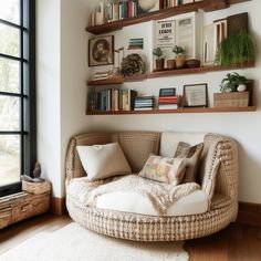 a living room filled with lots of furniture and books on the wall above it is a round wicker chair