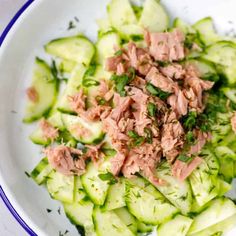 cucumber salad with smoked salmon and herbs in a white bowl