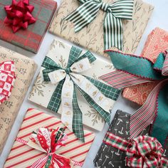 several wrapped presents with bows and ribbons on top of each other in various patterns, colors and shapes