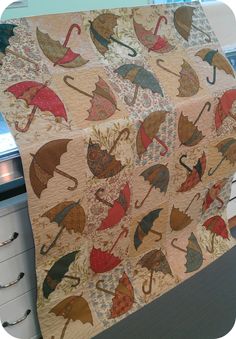 an umbrella quilt hanging on the side of a kitchen counter