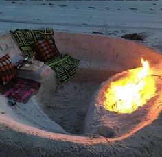 a fire pit sitting on top of a sandy beach