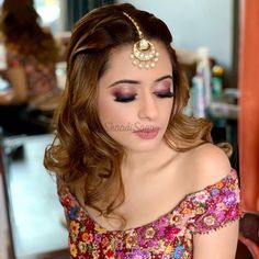 a woman with long hair wearing a flowered dress and headpiece in front of a mirror