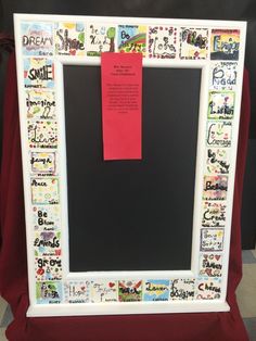 a white frame with stickers on it and a red note pinned to the front