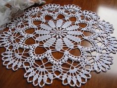 a crocheted doily on a wooden table