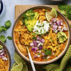 two bowls filled with chicken tortilla soup and garnished with sour cream