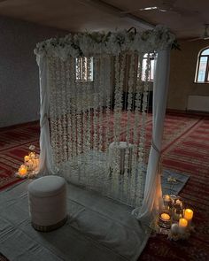 a decorated stage with candles and flowers on the floor in front of it for a wedding ceremony