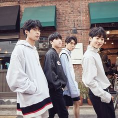 four young men standing in front of a store