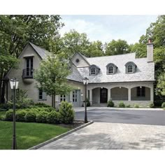 a large house with lots of windows and bushes in front of the entrance to it