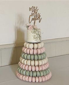 a wedding cake made out of macaroons and topped with a topper that says mr & mrs cosy