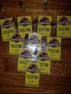 a bunch of yellow visitor tags on a wooden floor with clippings attached to them