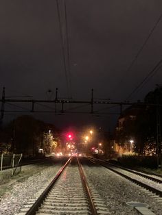 a train track at night with the lights on