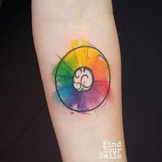 a colorful tattoo on the arm that has a symbol in it and an ombretta